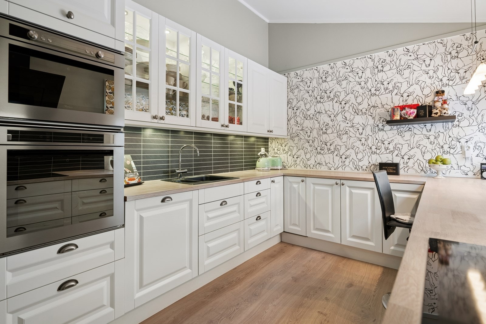 Innredningen er levert av Aubo og består av profilerte fronter som gir rommet et klassisk og tidløst preg. Benkeplaten i heltre tilfører varme og karakter, og gir samtidig en solid arbeidsflate for matlaging. Galleribilde