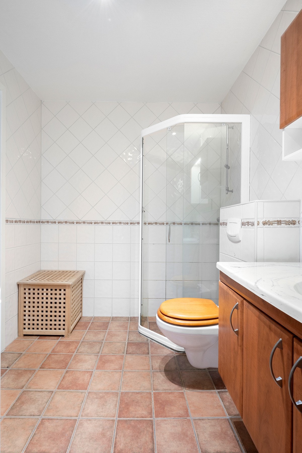 Baderom bestående av servant med underskap, toalett, dusjhjørne og opplegg vaskemaskin. Galleribilde