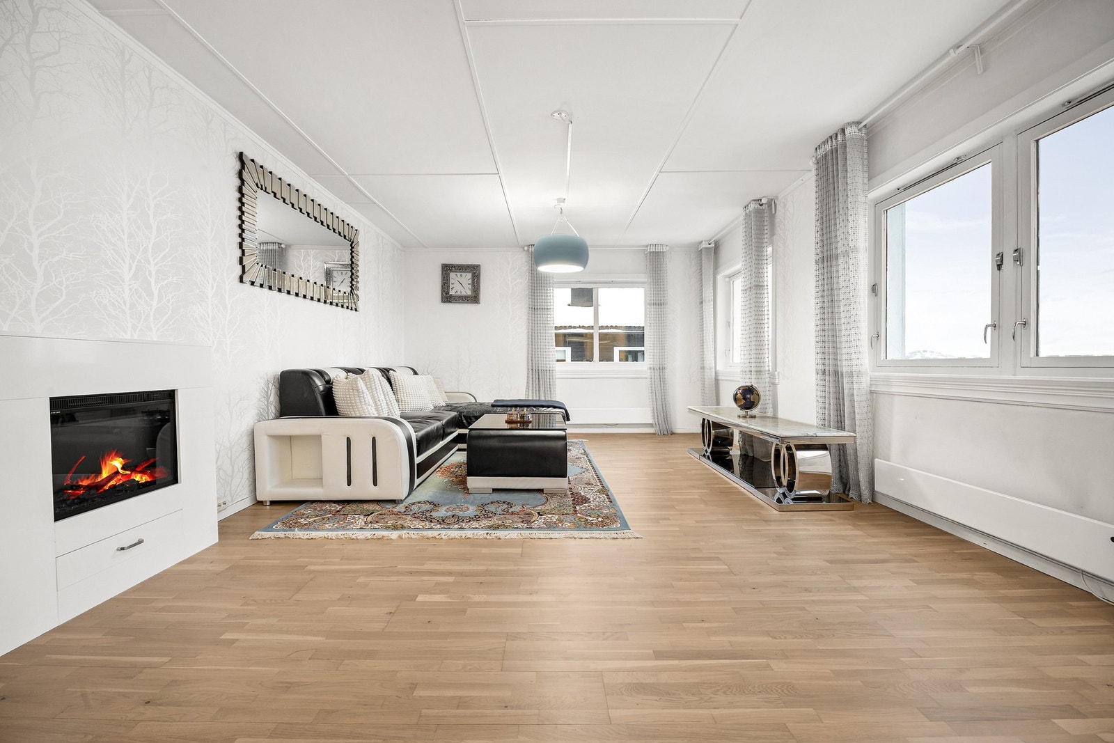 Romslig stue malt i lyse farger. 3-stavs parkett på gulv og malt himling Galleribilde