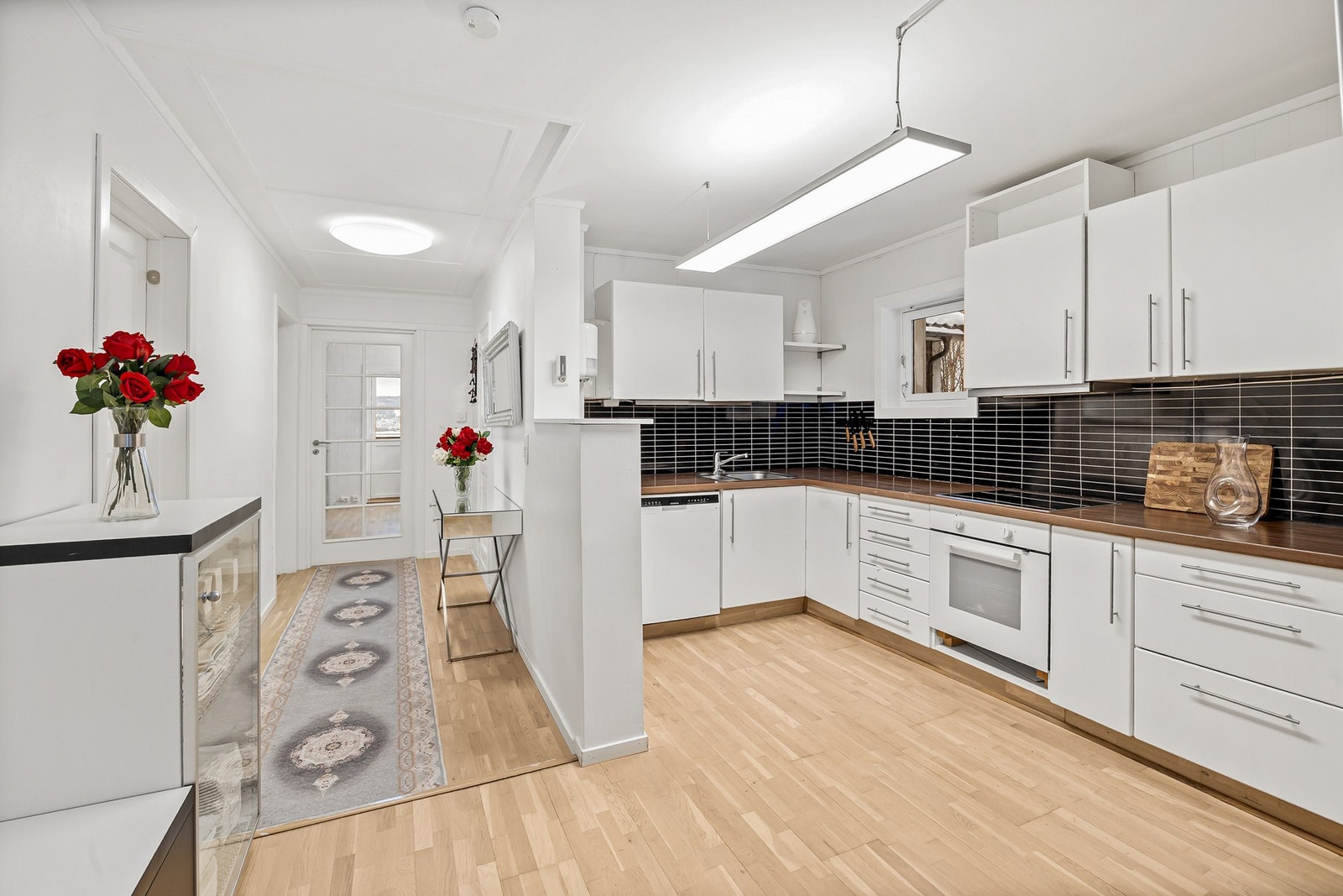 Nedfelt oppvaskkum med ett-greps armatur, kjøkkenplater mellom underskap og overskap Galleribilde