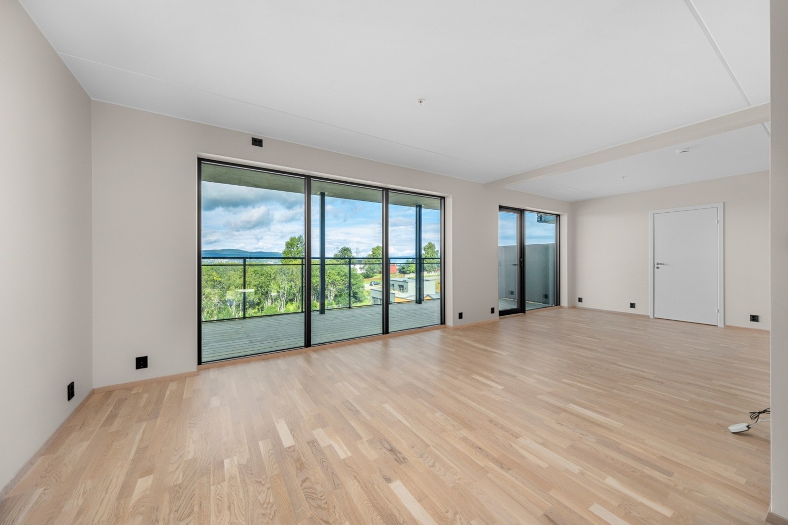 Stua har store vindusflater som strekker seg fra gulv til tak. Dette gir rikelig med naturlig lys. Galleribilde