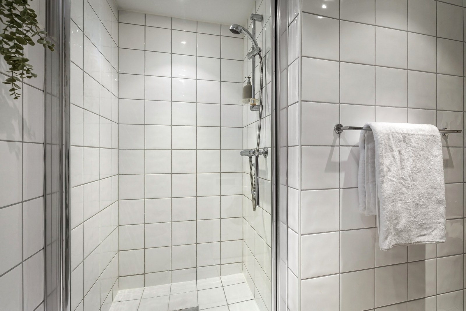 Dusjhjørnet har innfellbare glassdører og håndholdt dusj. Videre har badet opplegg for vaskemaskin. Galleribilde