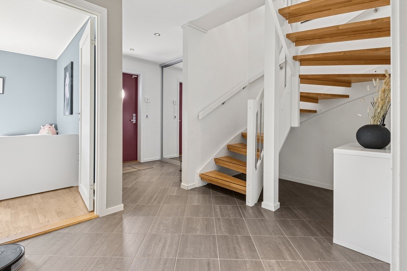 Inngangspartiet er åpent og romslig med skyvedørsgarderobe som har god plass til oppheng av yttertøy. Galleribilde