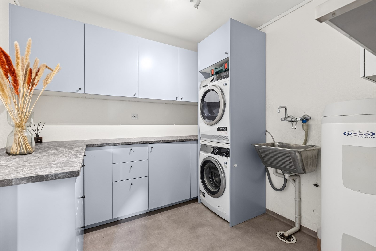 Eget romslig vaskerom med moderne, innbygget innredning, god oppbevaringsplass, utlsagsvask og praktisk arbeidsbenk. Galleribilde