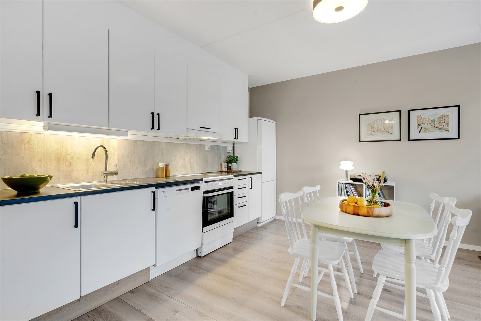 Flott kjøkken gjennomført i lyse overflater med rikelig skap- og benkeplass. Galleribilde