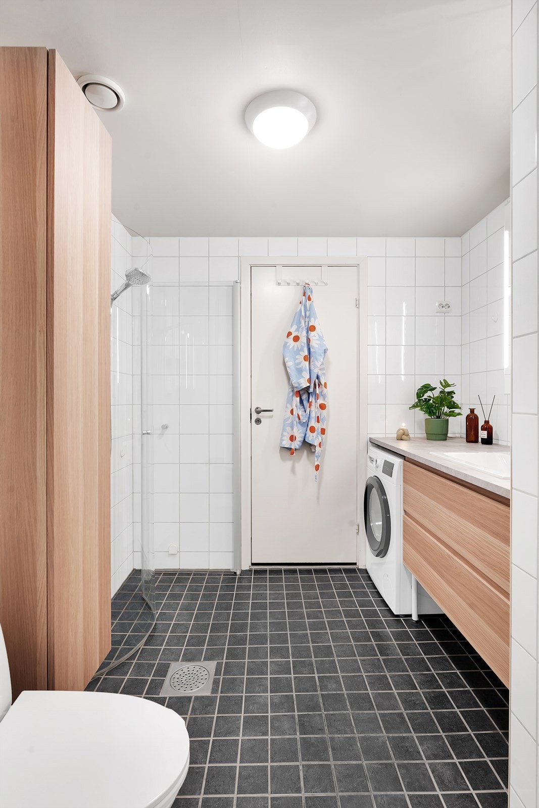 Komplett flislagt bad med praktiske innredninger og opplegg for vaskemaskin. Galleribilde