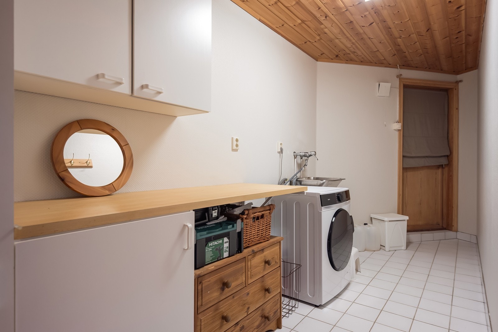 Eget praktisk vaskerom med flislagt gulv og egen ytterdør. Av installasjoner er det utslagsvask, opplegg for vaskemaskin og tørketrommel. Galleribilde