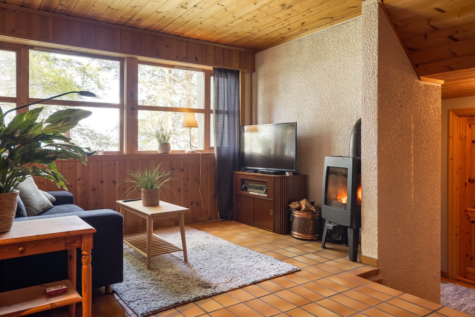 Flott kjellerstue med flislagt gulv, store vindusflater og god plass til sofagruppe. Galleribilde