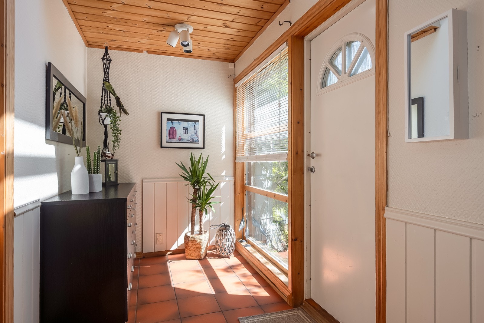 Romslig og flislagt entrè med rikelig av plass til ytterklær og sko. Galleribilde