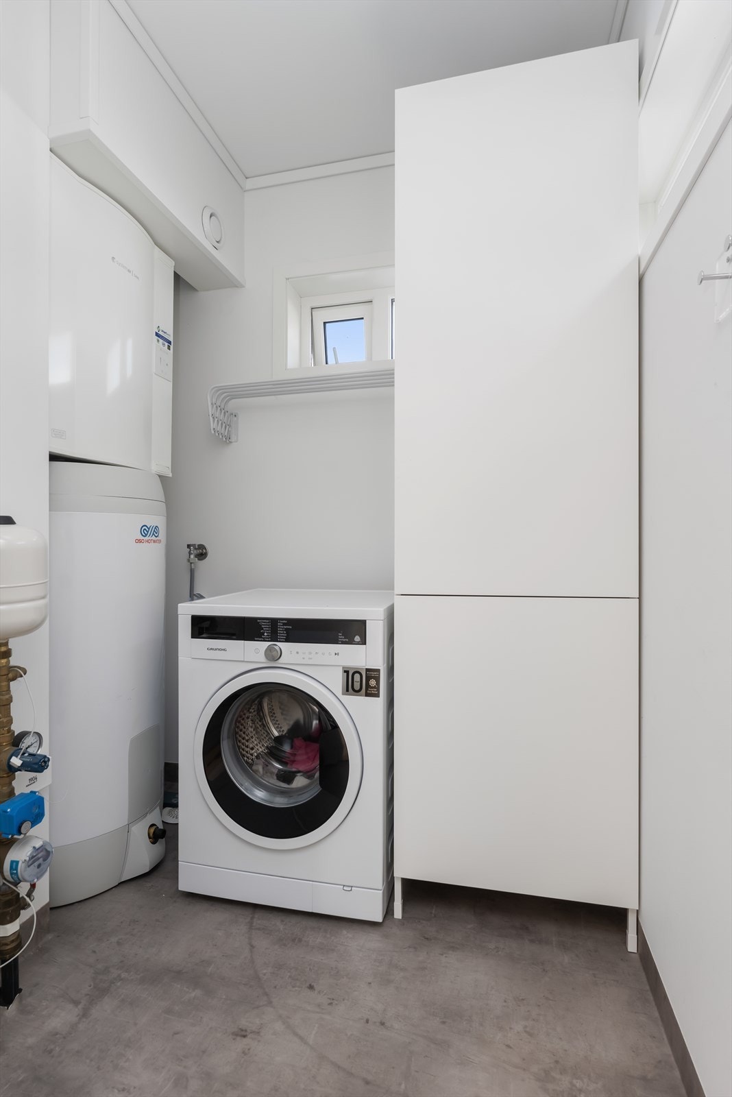 Vaskerom/teknisk rom med et stort garderobeskap Galleribilde