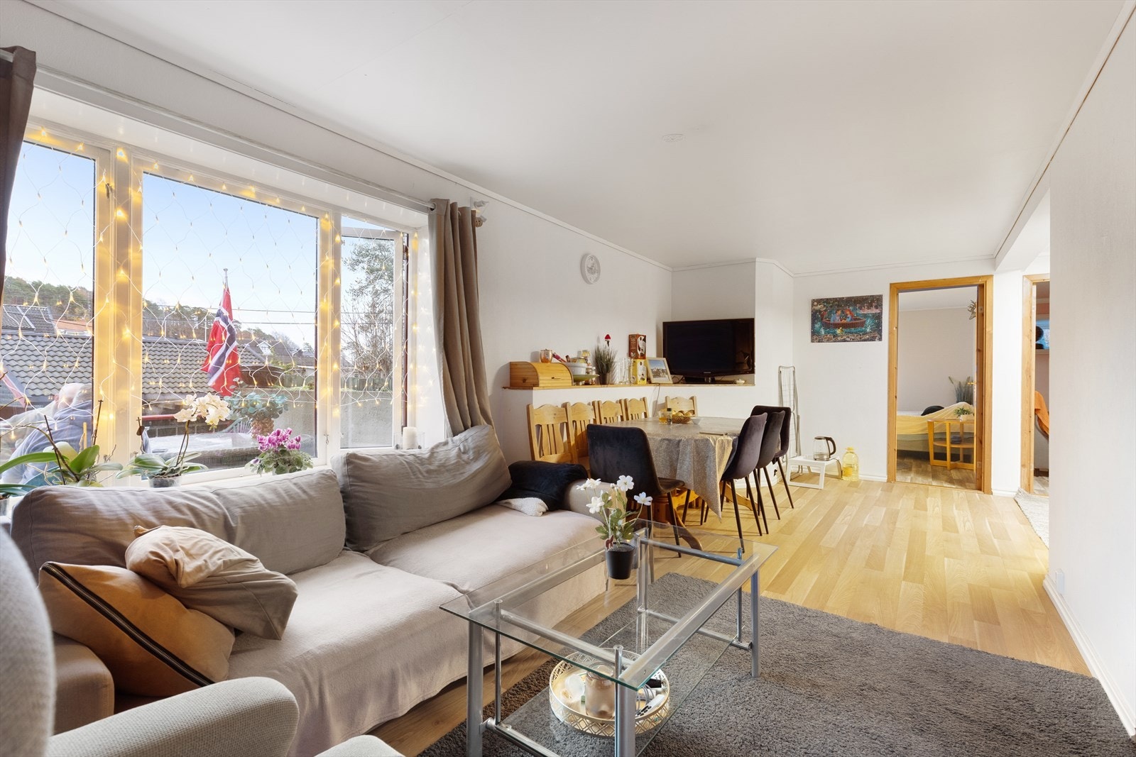 Hybelleiligheten har stue med store vindusflater, og plass til både sofagruppe og spisestuebord. Galleribilde