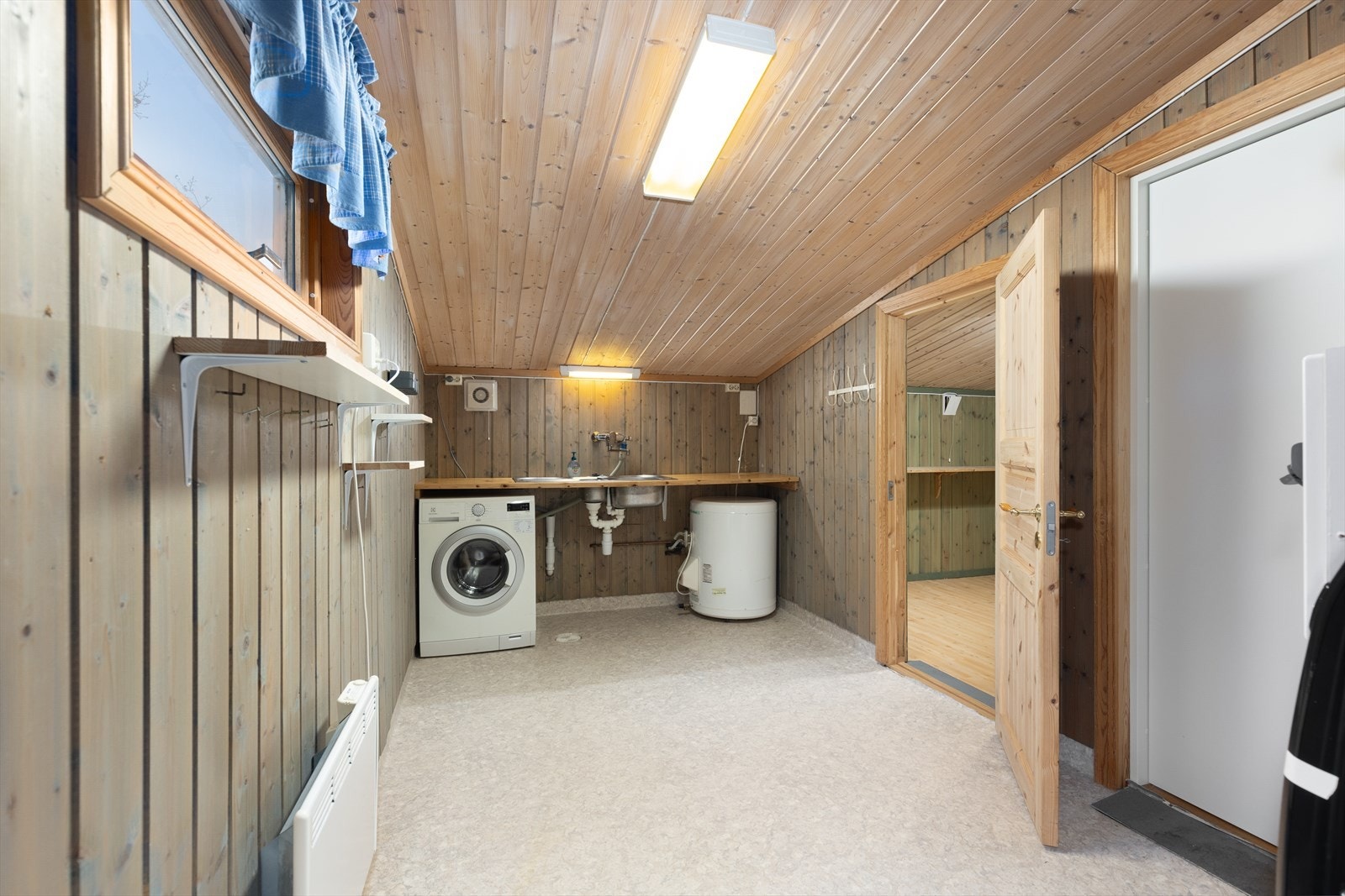 Her er det et romslig vaskerom med vinylbelegg på gulv og panel på vegger. Det er opplegg for vaskemaskin, en praktisk benkeplate med nedfelt skyllekar og elektrisk styrt vifte. 116l vvt er plassert på vaskerom. Rommet har også egen inngangsdør. Galleribilde