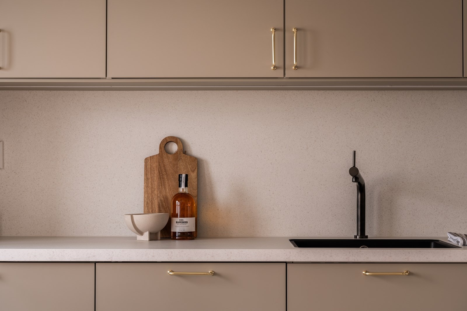 Detaljer som sort blandebatteri og underlimt vask understreker den gjennomførte stilen. Galleribilde