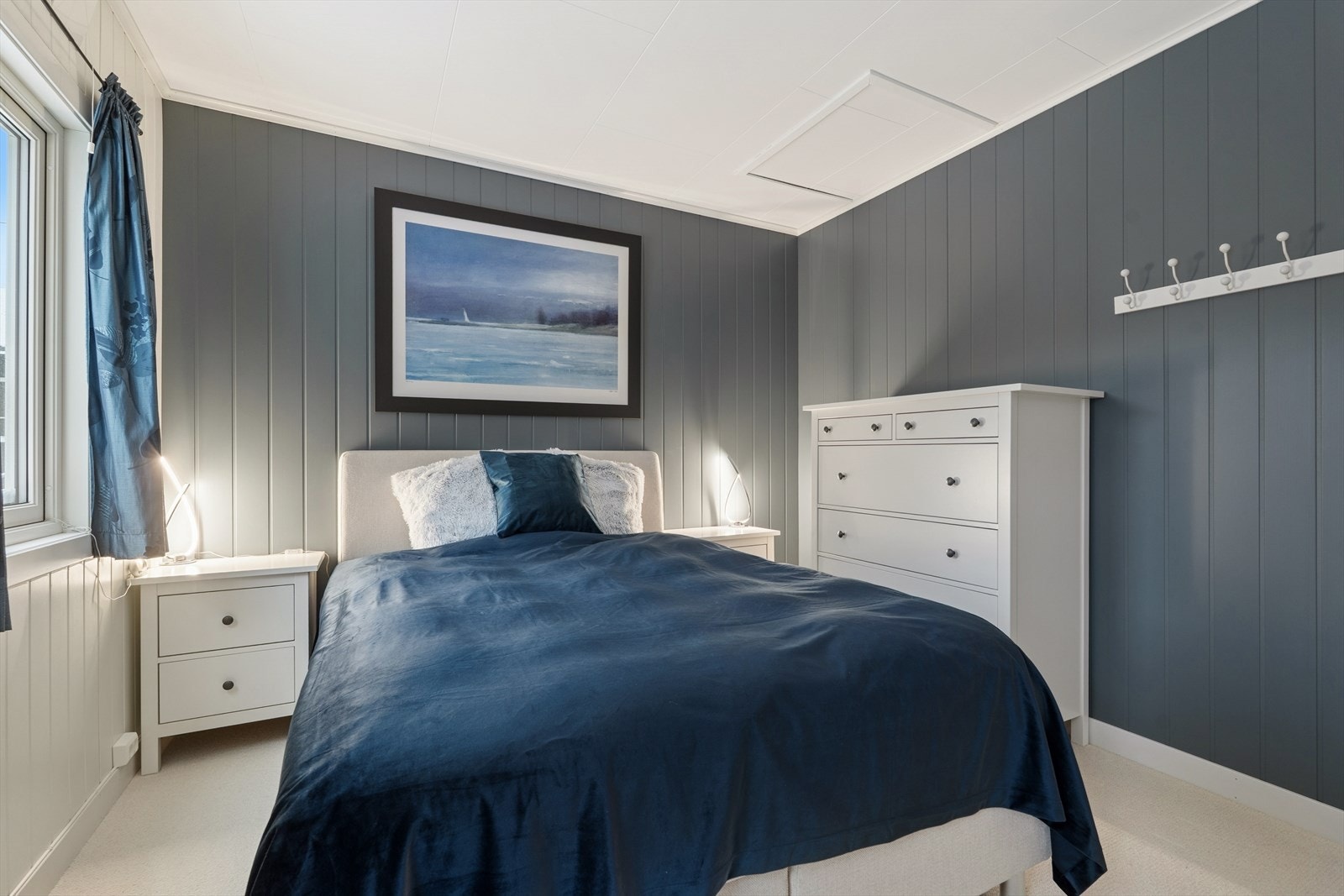 Lyst og behagelig soverom malt i en dus, tidsriktig farge med god plass til dobbeltseng. Galleribilde