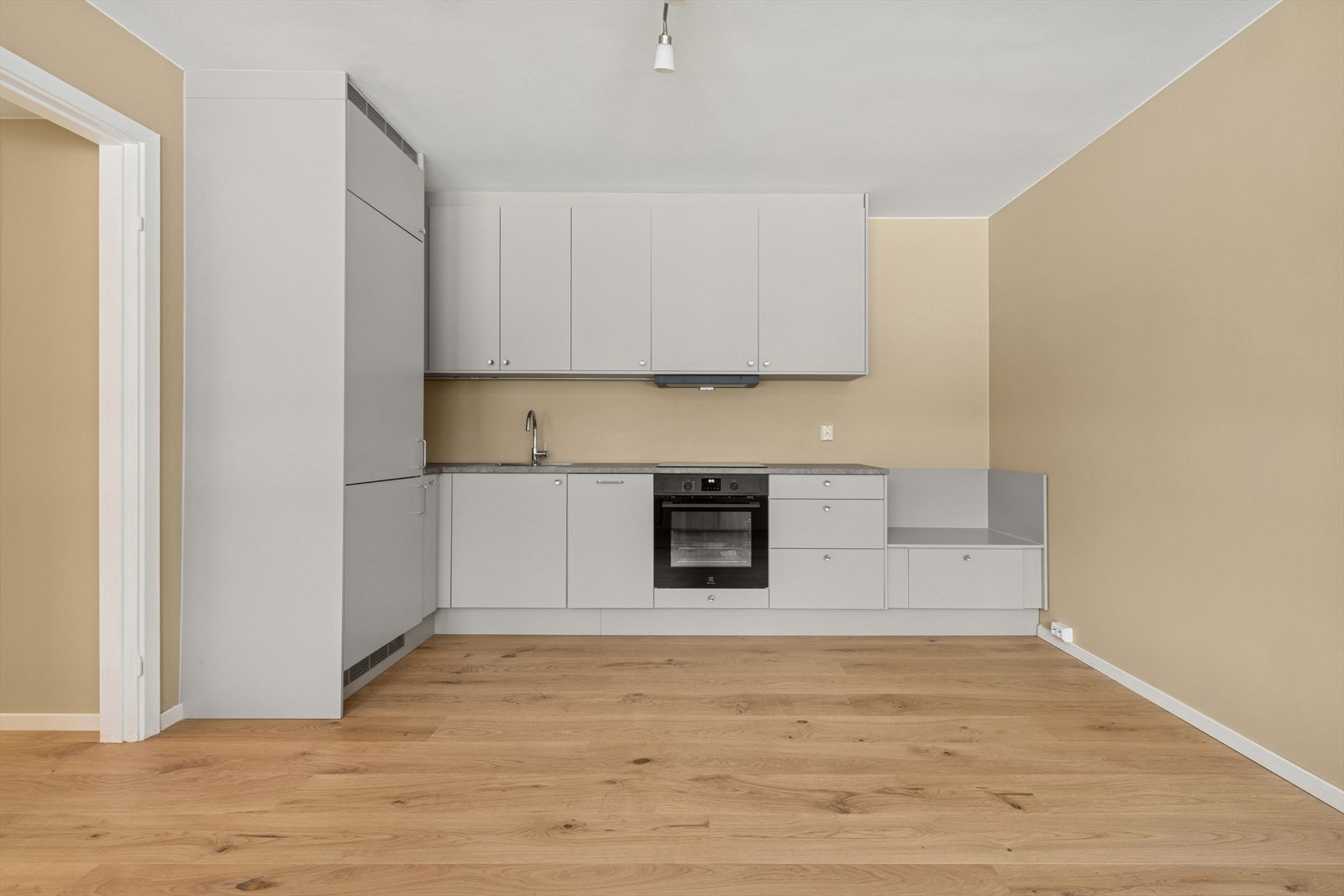 Den er utstyrt med integrert kjøl/fryseskap, 45 cm oppvaskmaskin, induksjonstopp og stekeovn. Galleribilde