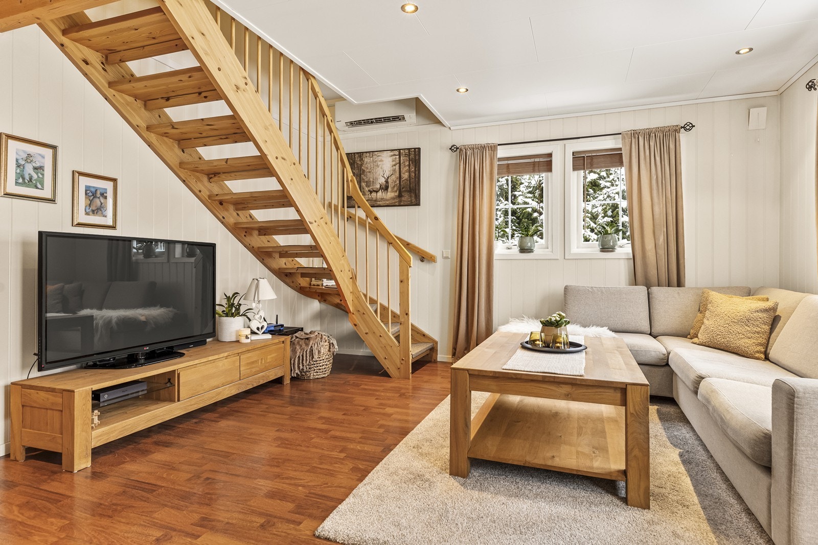 En trapp i lakkert tre leder opp til boligens andre etasje. Galleribilde