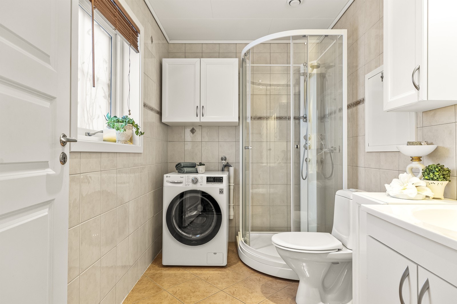 Baderommet ligger i første etasje. Gulv og vegger er flislagt med en standard i fra byggeåret. og har opplegg for vaskemaskin. Dusjkabinettet ble skiftet i 2021. Galleribilde