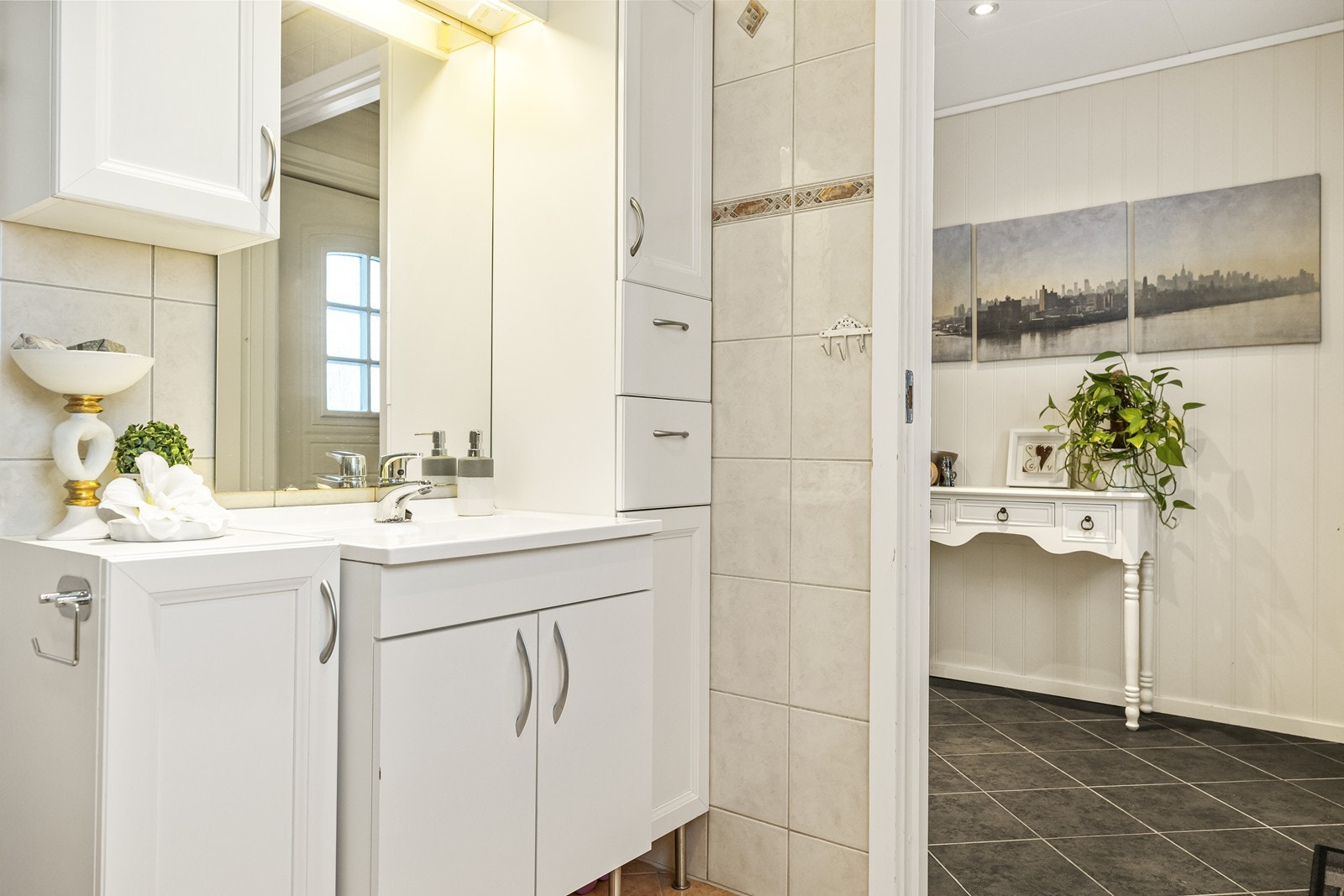 Rommet er innredet med servant og skapinnredning med slette fronter, i tillegge er det montert et høyskap og et overskap, og et underskap underskap, for ekstra god oppbevaringsplass. Galleribilde