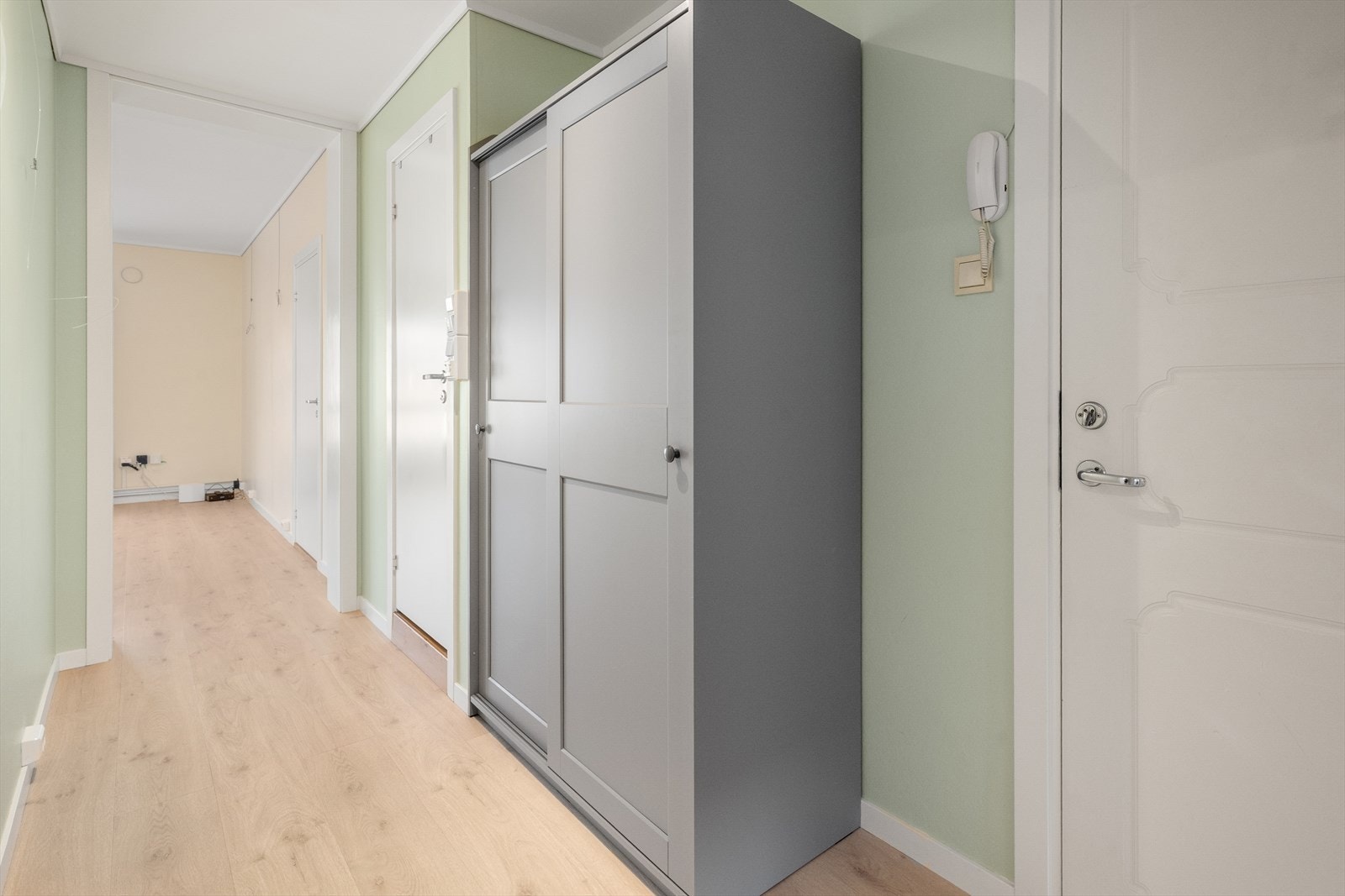 Fin entré med garderobeskap og praktisk dørtelefon. Innvendige overflater består hovedsakelig av laminat på gulv og malt tapet på vegger. Galleribilde