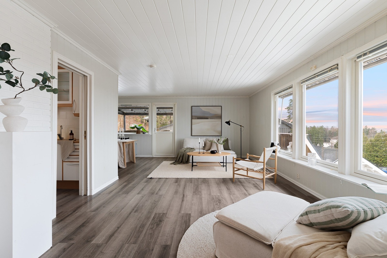 Boligens eleverte beliggenhet kombinert med vinduer i både syd- og vestveggen gjør stuen luftig og lysfylt. Galleribilde