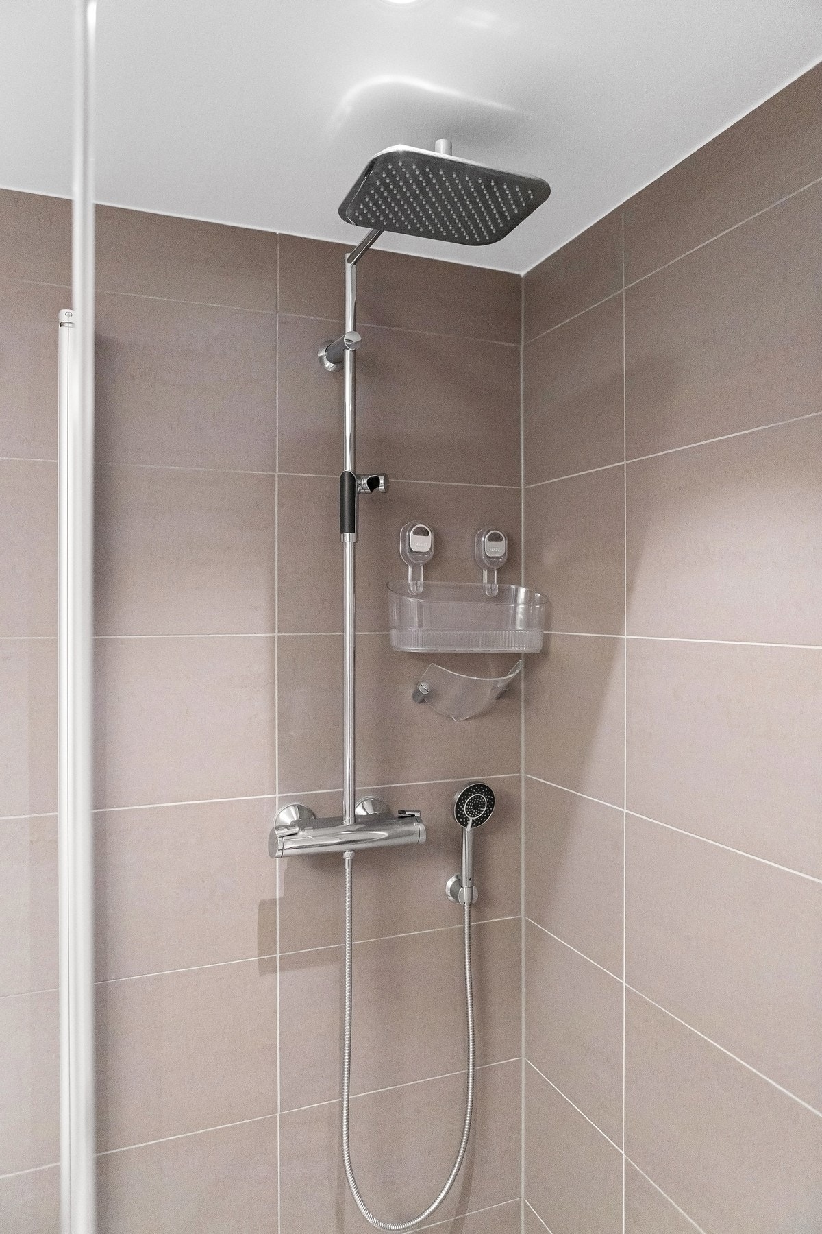 Videre inneholder badet vegghengt toalett og nedsenket dusjhjørne med innfellbare glassdører. Galleribilde