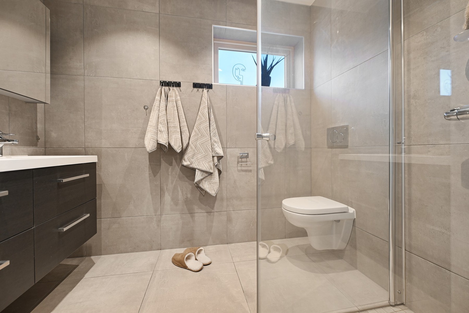 Gulvet har varmekabler, og det er dusjhjørne og vegghengt toalett. Himlingen har innfelte downlights. Galleribilde