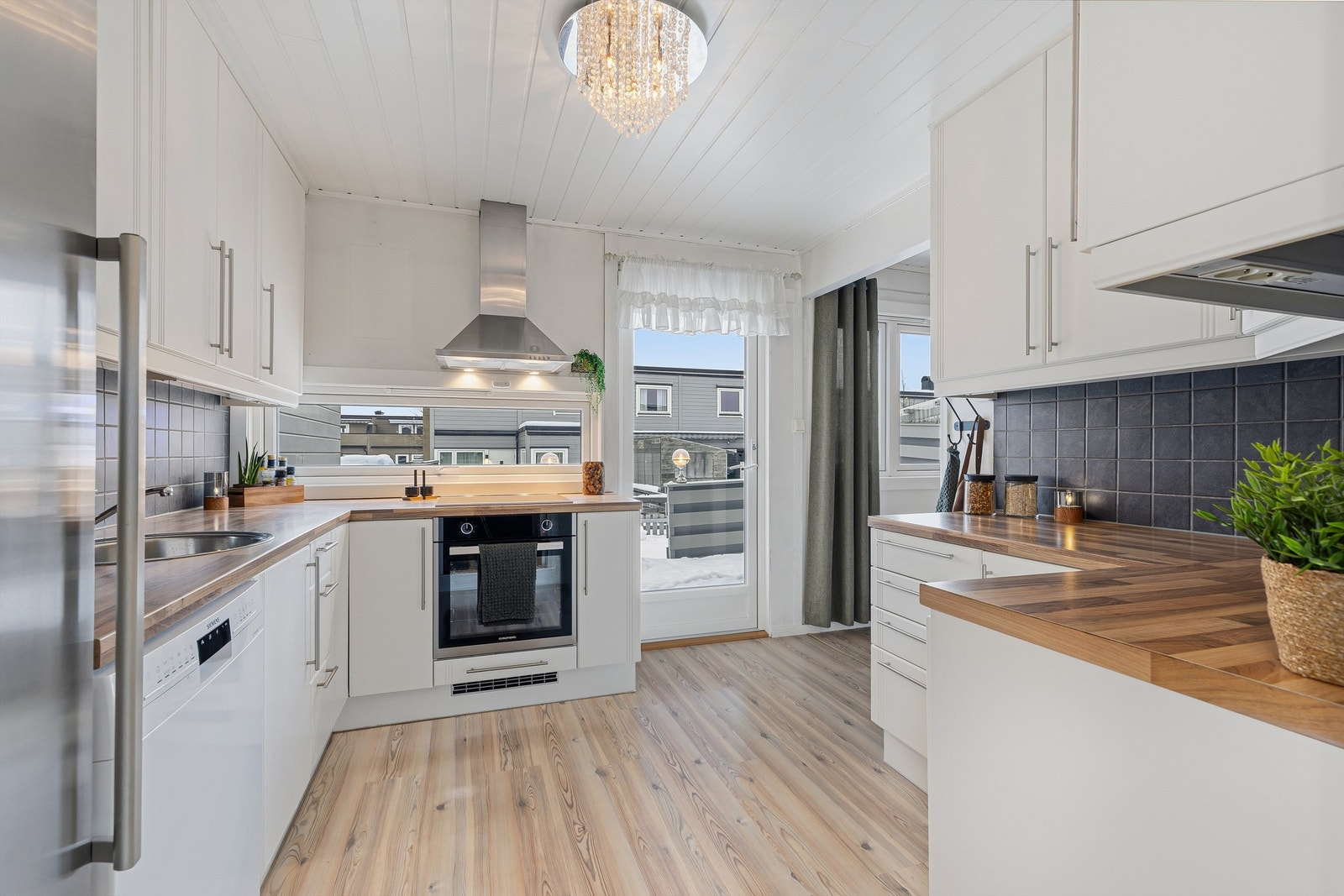 Kjøkkenet har innredning med glatte fronter og utgang til en nordvendt terrasse på 18 m². Galleribilde