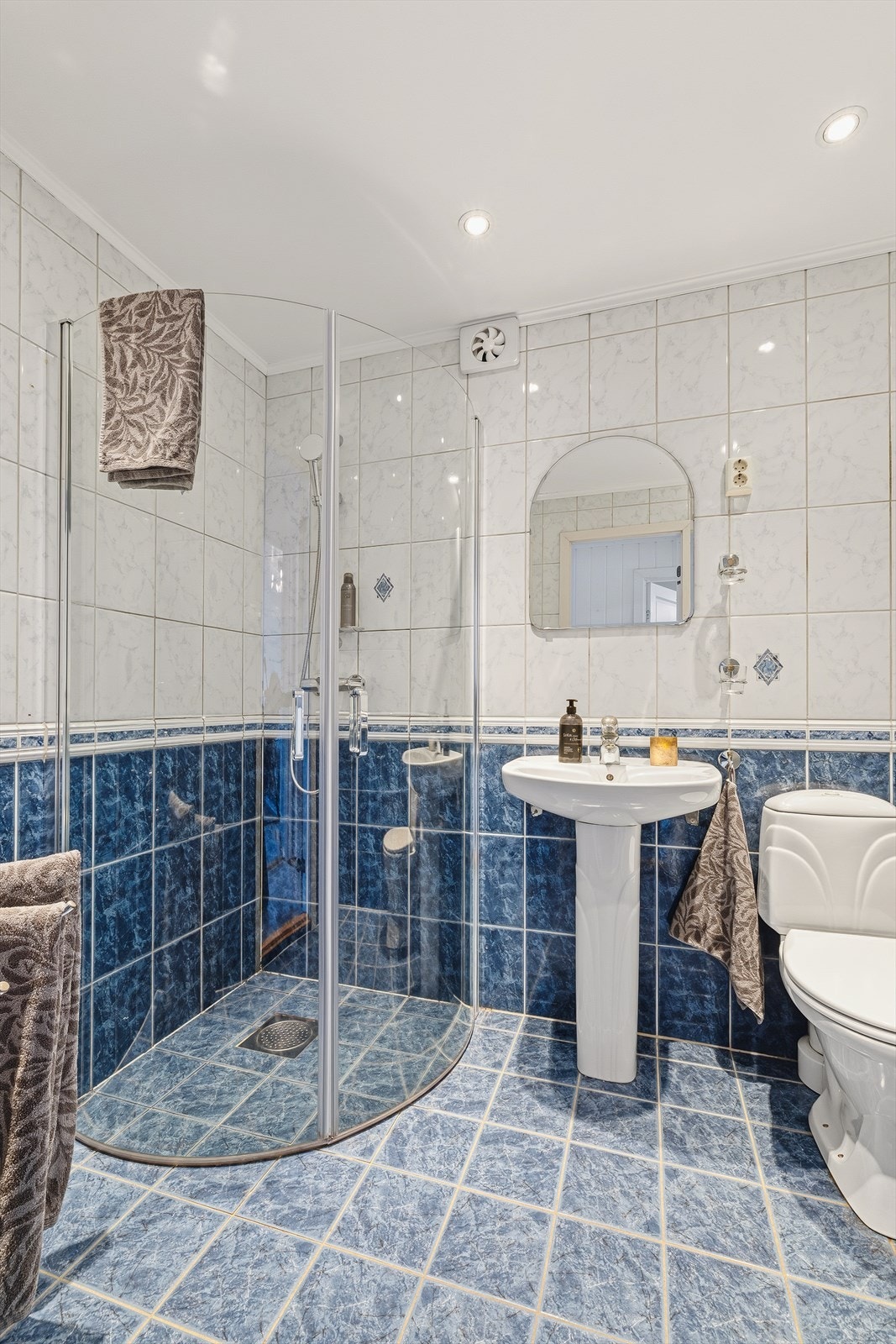 Rommet er utstyrt med dusjhjørne, servant, toalett og nedsenket himling med downlights. Galleribilde