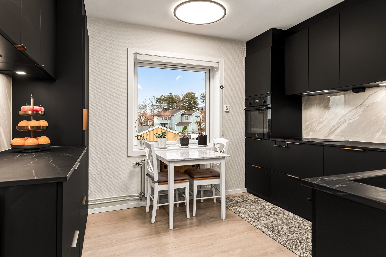 Moderne og meget innbydende kjøkken med integrerte hvitevarer og egen spiseplass Galleribilde