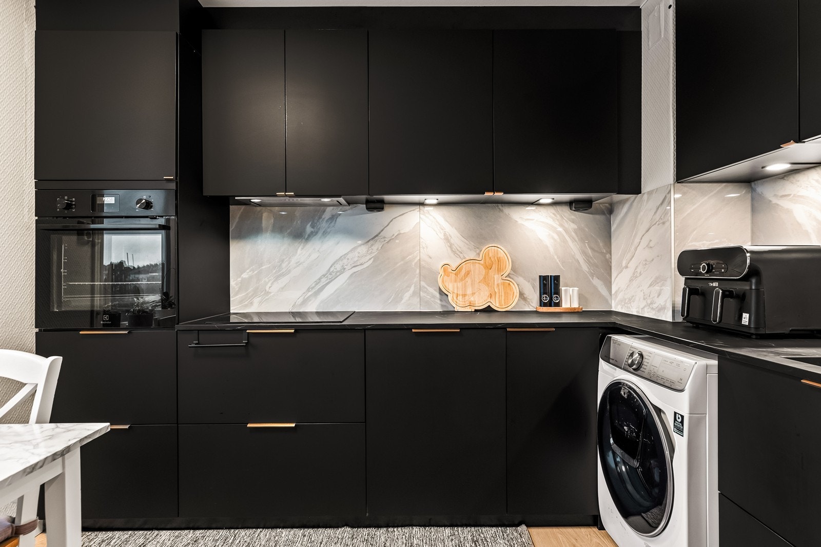 Innredning opp til himlingen med slette skapfronter og integrerte hvitevarer Galleribilde