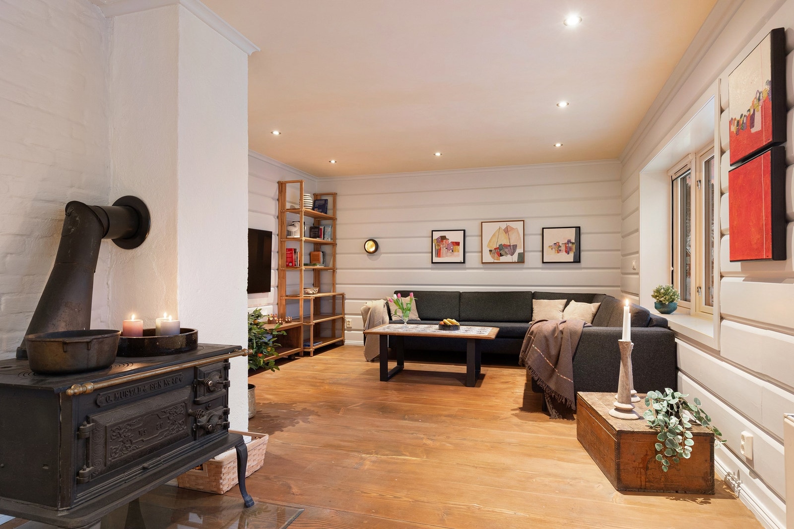 Hyggelig innredet stue med vedfyrt kjøkkenovn Galleribilde