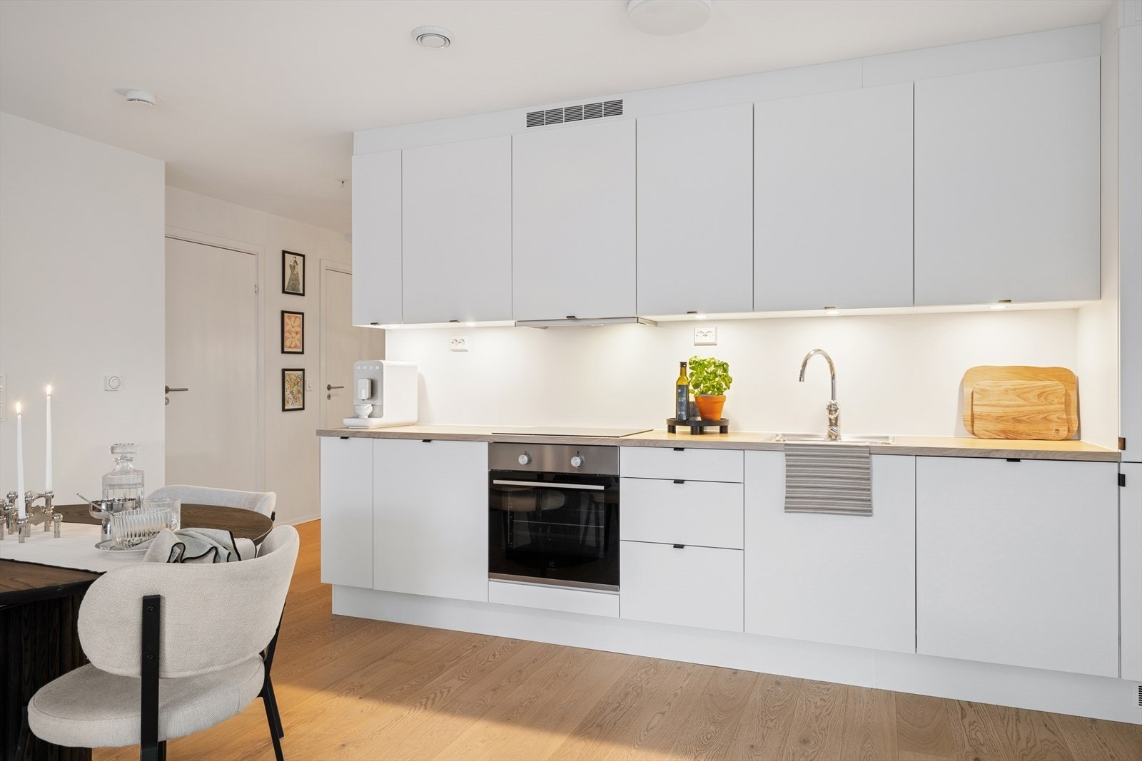 Det er montert belysning under overskapene for godt arbeidslys. Kjøkkenet er utstyrt med integrerte hvitevarer som kjøl/fryseskap, oppvaskmaskin, induksjonstopp med komfyrvakt og stekeovn. Galleribilde