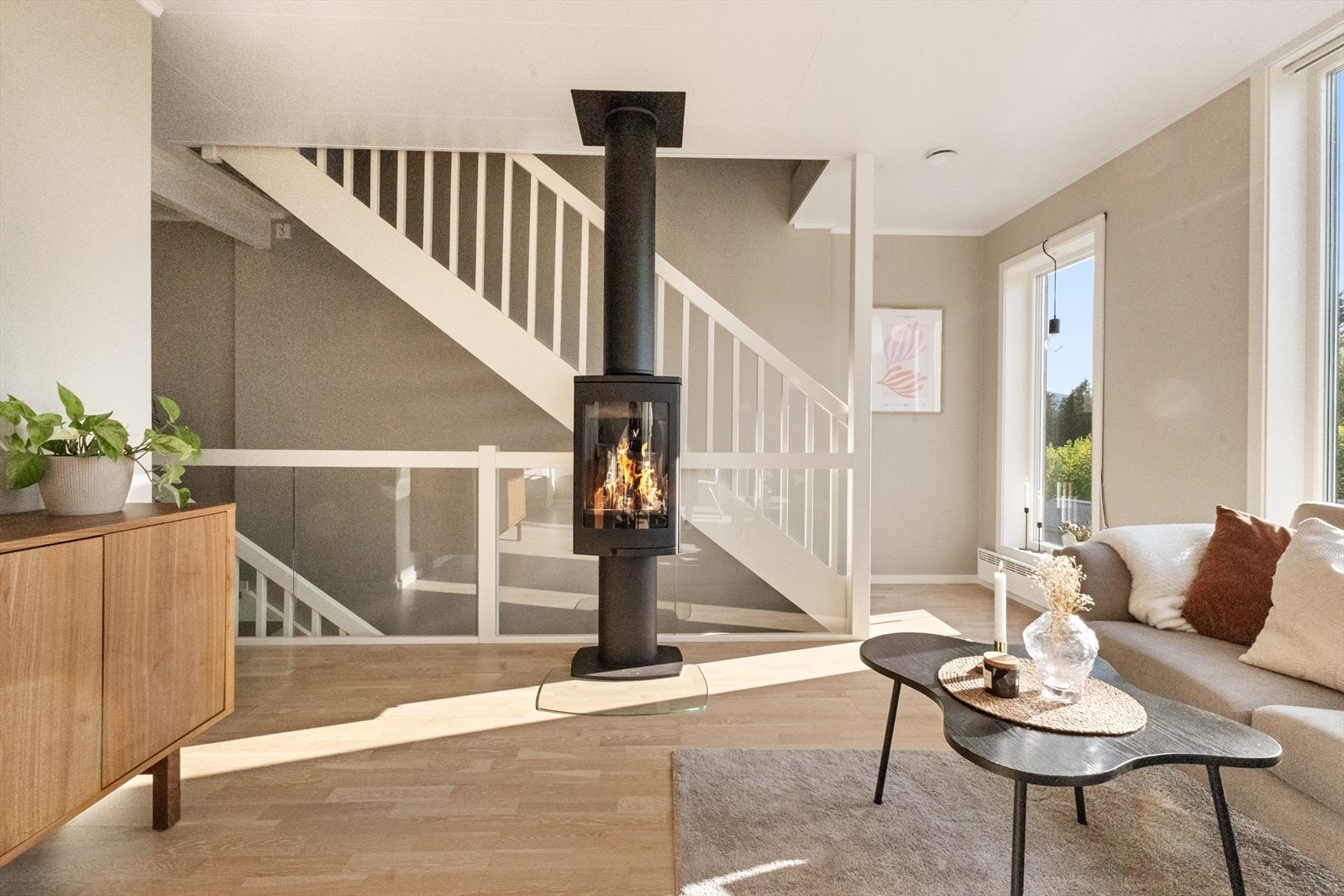 Mot trappegang som forbinder de 3 etasjene sammen. Det er glassrekkverk i stuen. Galleribilde