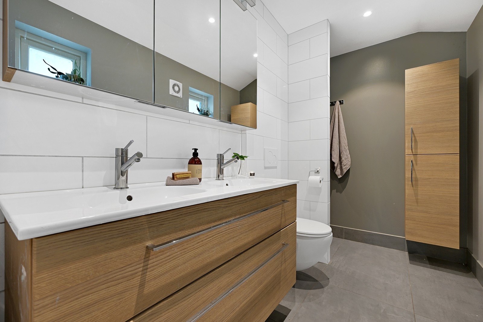 Hovedetasjen byr i tillegg på et meget lekkert baderom med flislagt gulv i en pen gråfarge. Her har eier tatt tidsriktige fargevalg Galleribilde