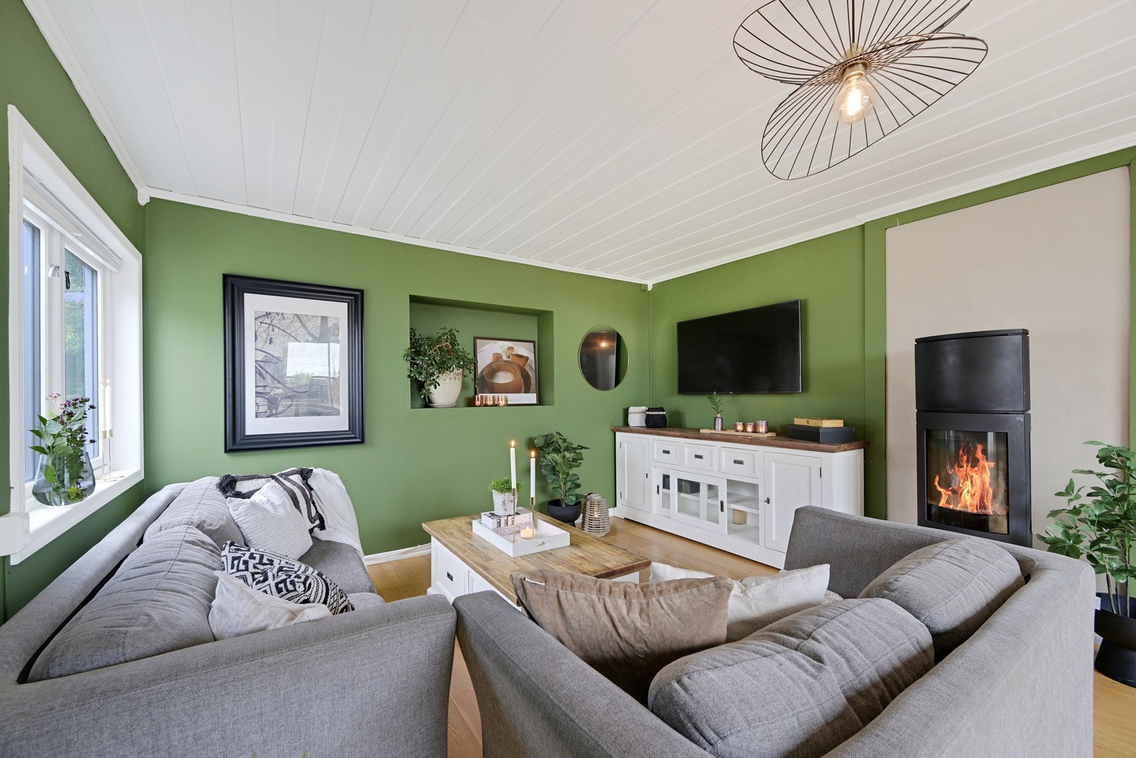 Hjertet av boligen er romslig og tilbyr godt med plass til møblement. Her har man en lekker peisovn som varmer godt når kulden setter inn Galleribilde