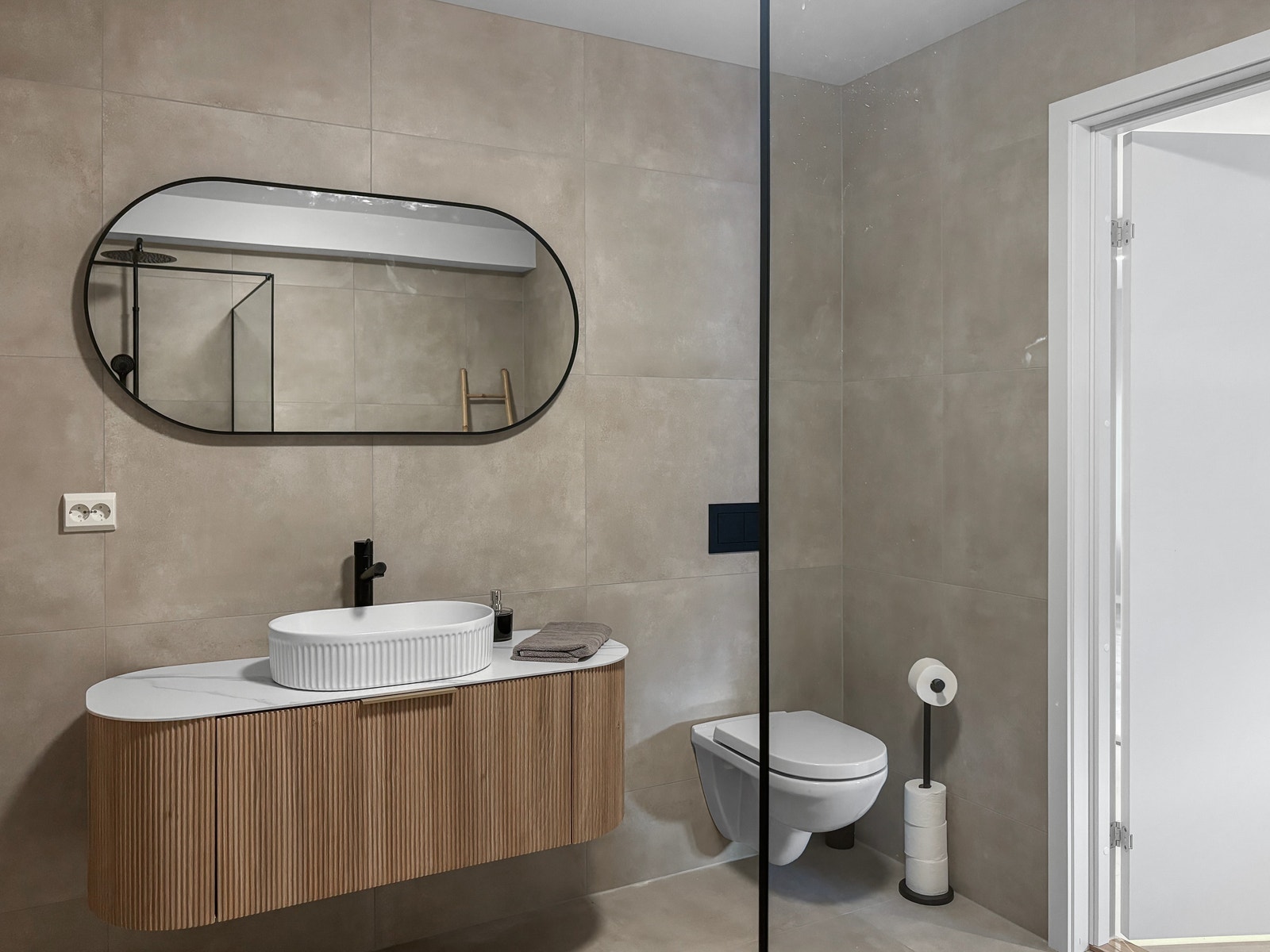 Baderom har sorte deltaljer som går igjen i leiligheten. Galleribilde