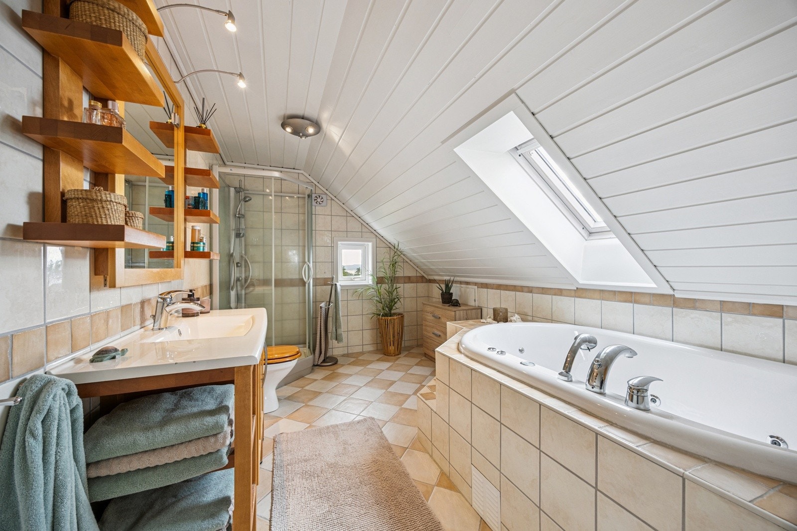 Badet i 2. etasje er innbydende og delikat flislagt med lyse, nøytrale fliser på både gulv og vegger, noe som gir et rent og tidløst uttrykk. Galleribilde