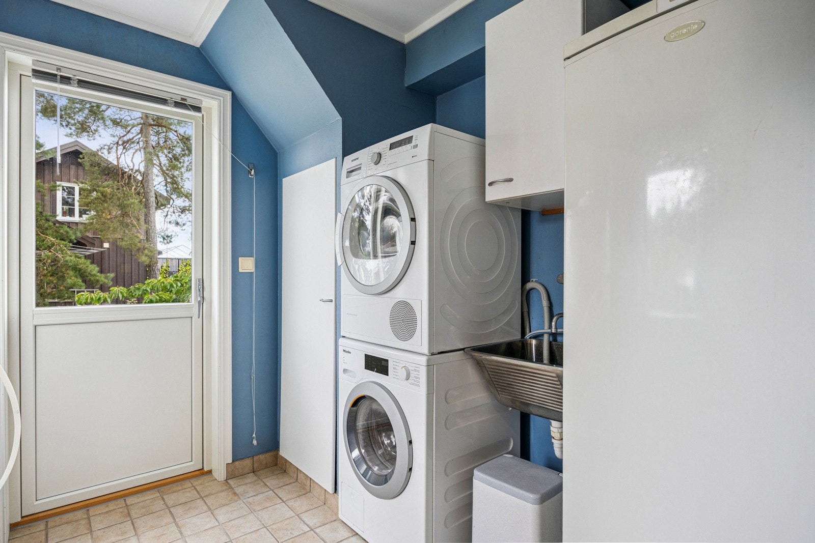 Praktisk vaskerom med direkte utgang til terreng. Vaskerom med flis på gulv, malte plater i taket og på vegg. Galleribilde