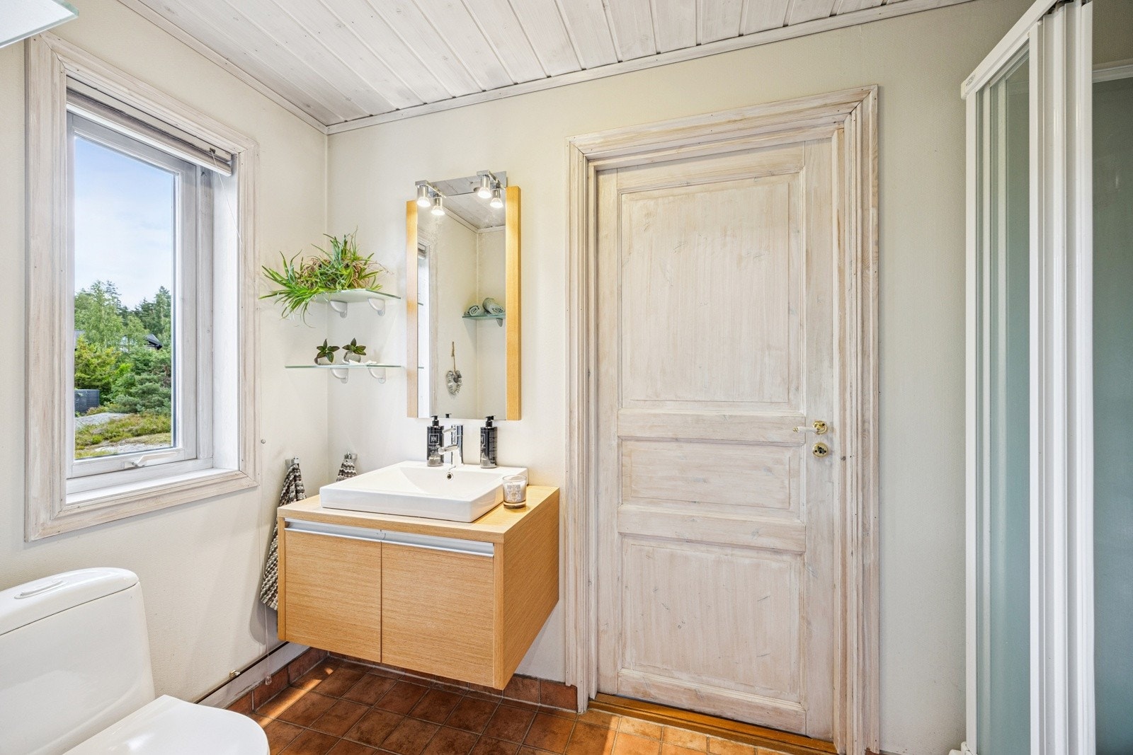 Badet i 1. etasje er innredet med dusjkabinett, servant i innredning og toalett. Galleribilde