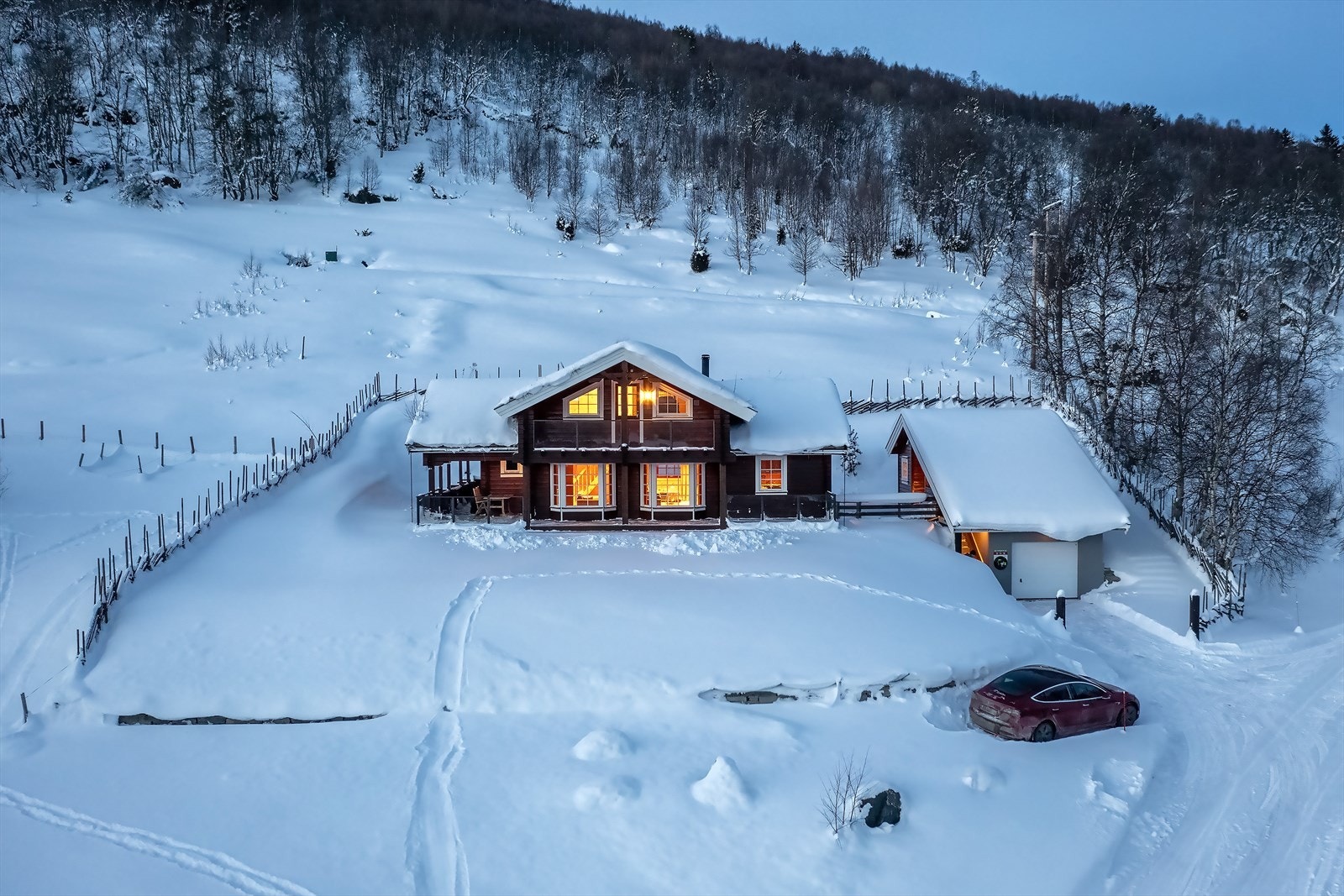 Tomten er pent opparbeidet og innrammet av skigard med adkomst via grind samt støttemur i naturstein Galleribilde