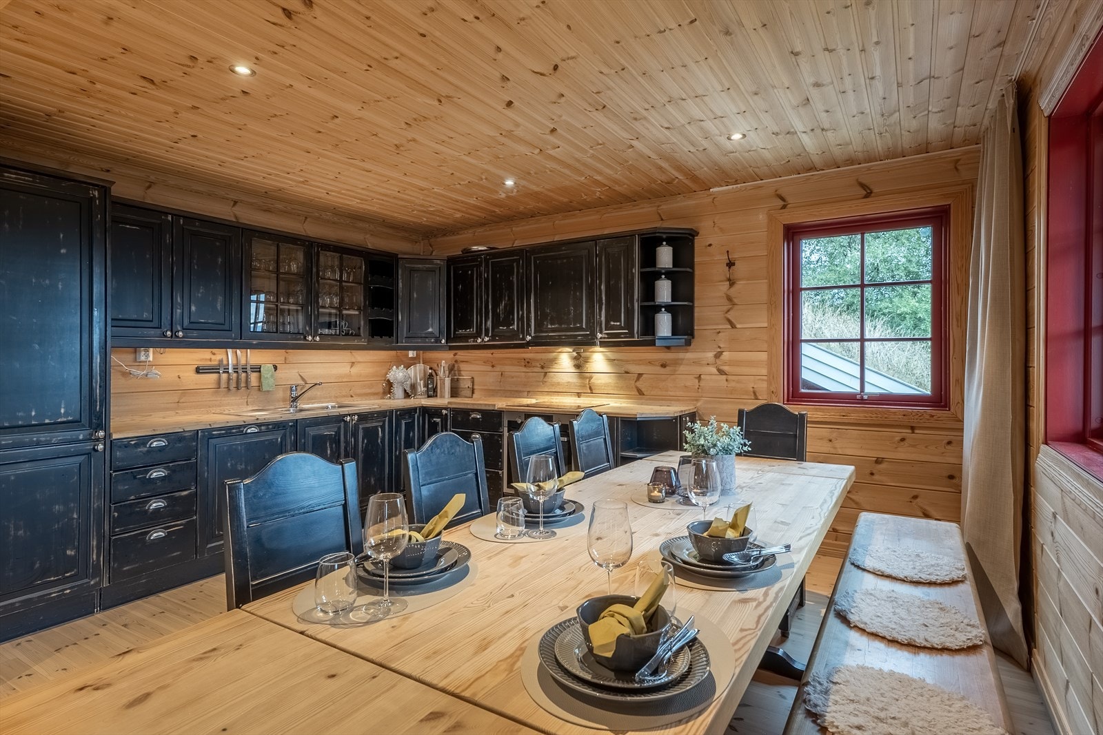 Kjøkkenet har heltreinnredning med aldringsmalte fronter og integrerte hvitevarer Galleribilde