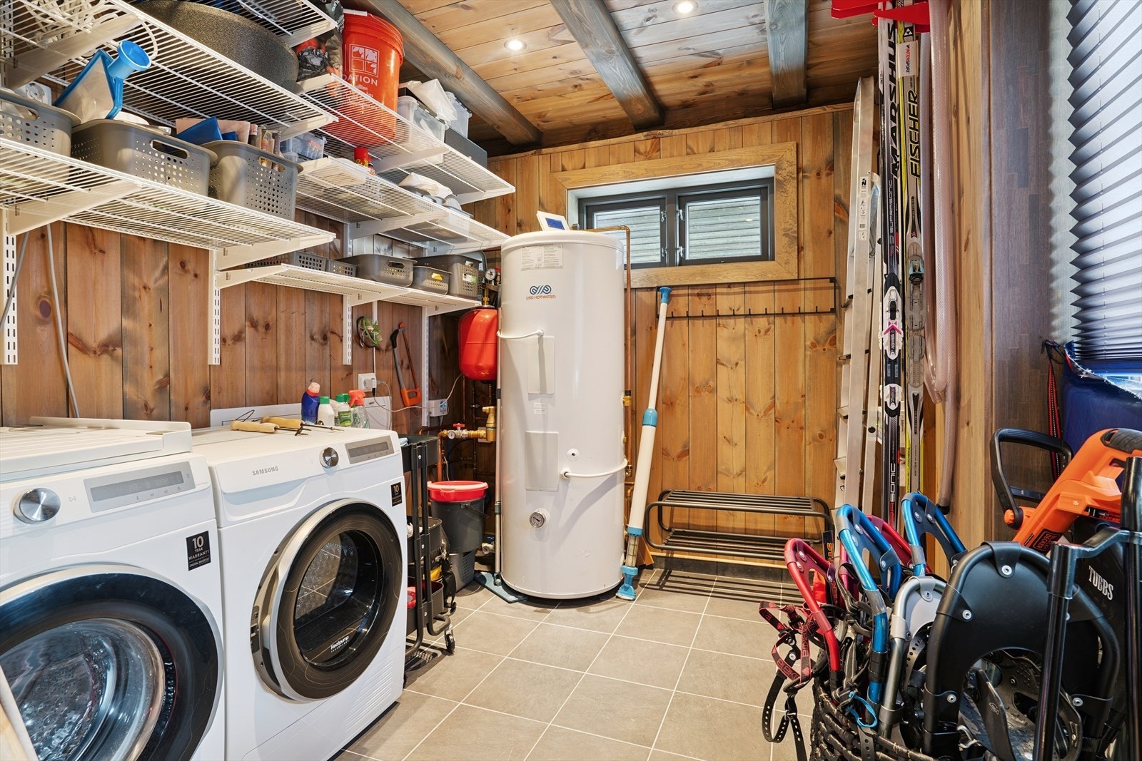 Vaskerom med flisbelagt gulv med sluk og downlights. Rommet er utstyrt med varmtvannsbereder og opplegg for vaskemaskin samt plass til tørketrommel. Galleribilde