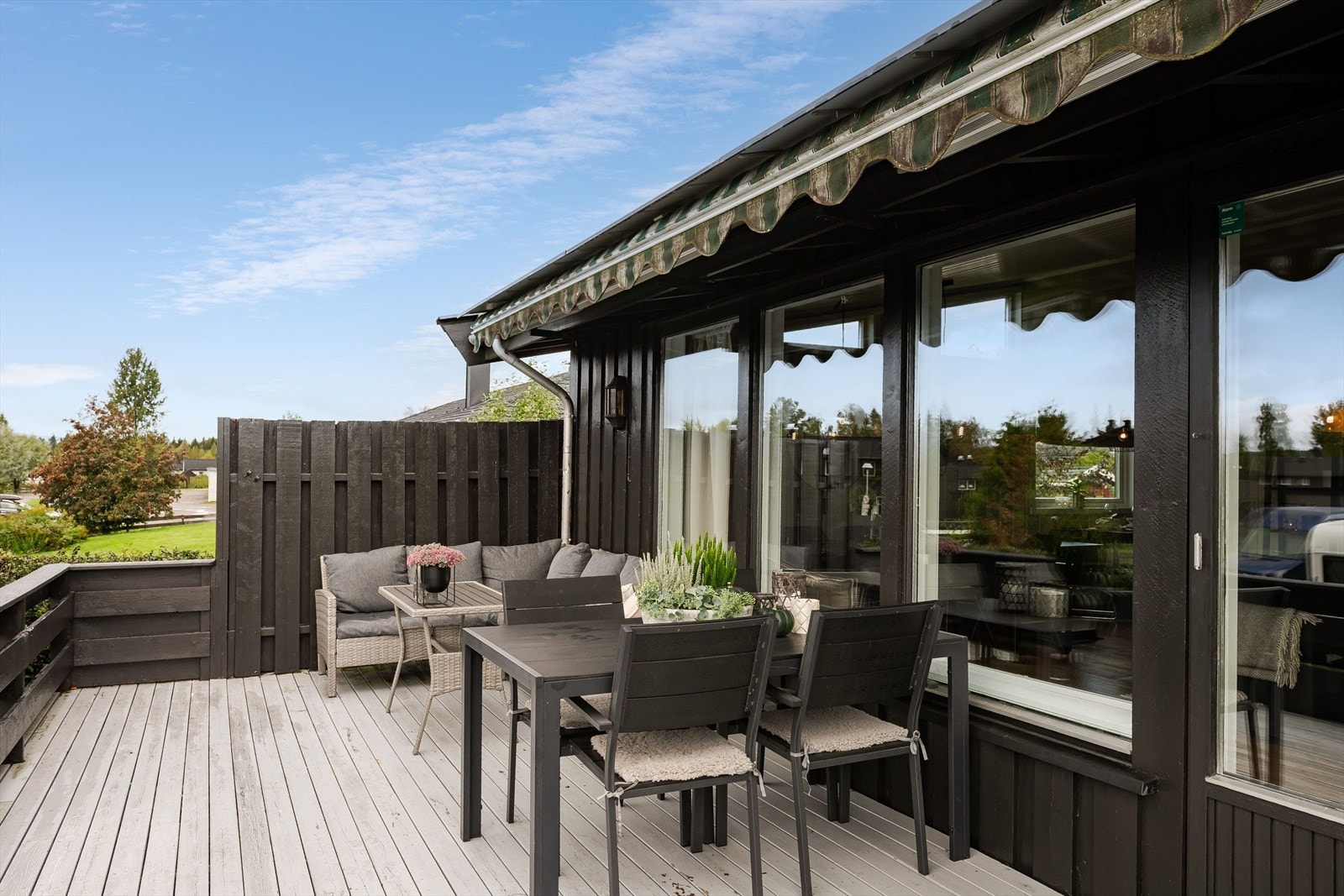 Fra stuen er det utgang til en solrik terrasse med levegg og markise. Galleribilde