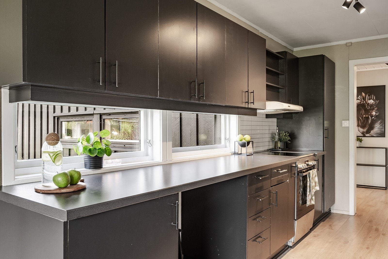 Kjøkkenet er innredet med frittstående hvitevarer som ikke medfølger i handelen. Vinduer mellom over- og underskap gir ekstra med belsyning. Galleribilde