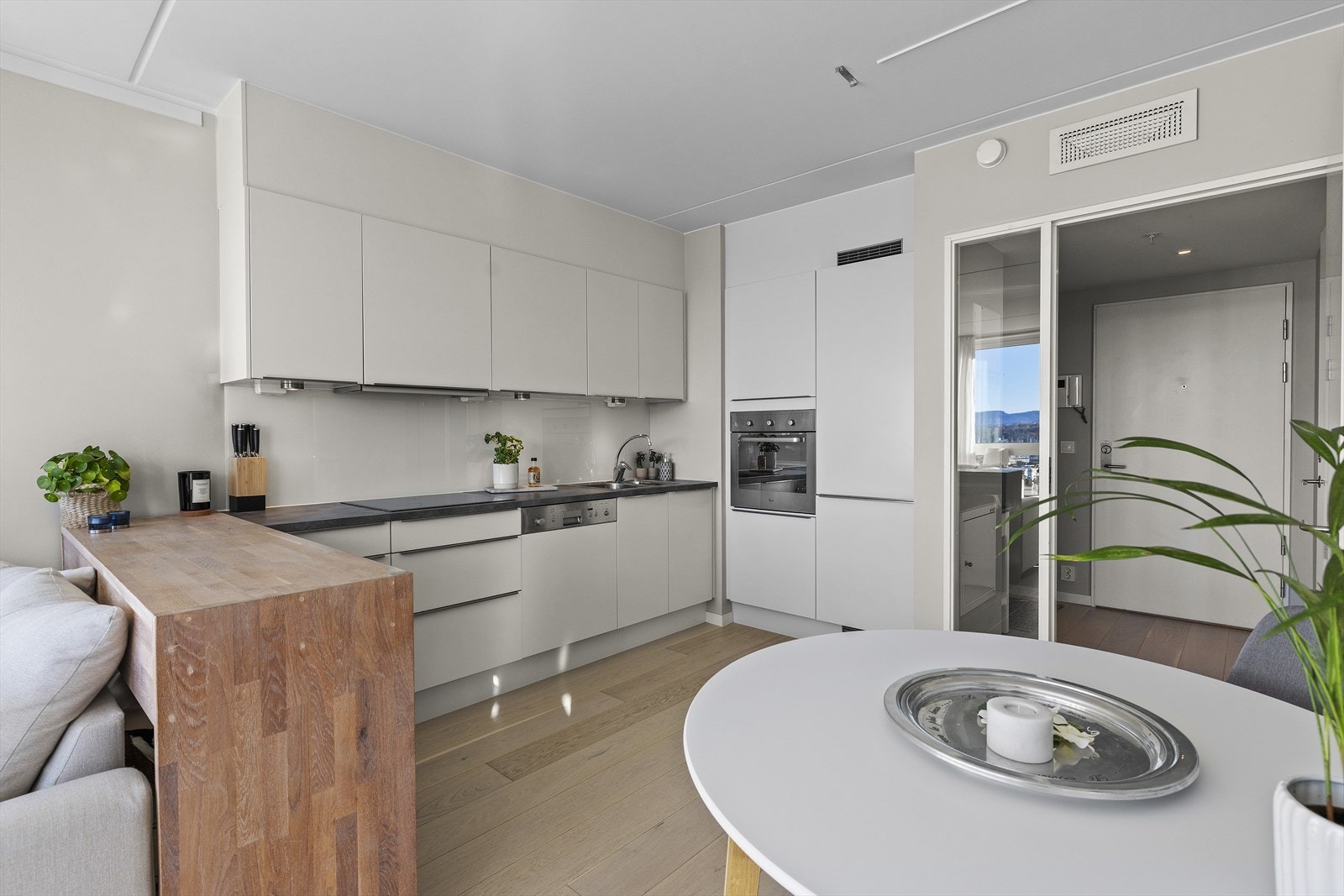 Kjøkkeninnredningen har hvite glatte fronter og integrerte hvitevarer. Galleribilde