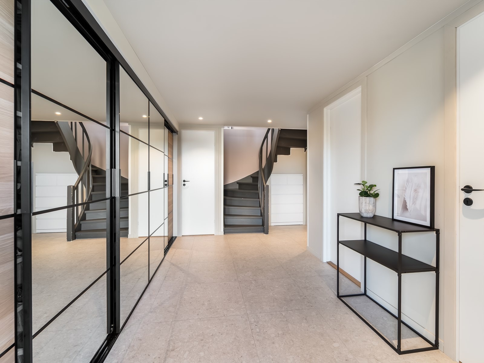 Innbydende og vid gang i underetasjen med stor skyvedørsgarderobe. Varmekabler i gulv. Galleribilde