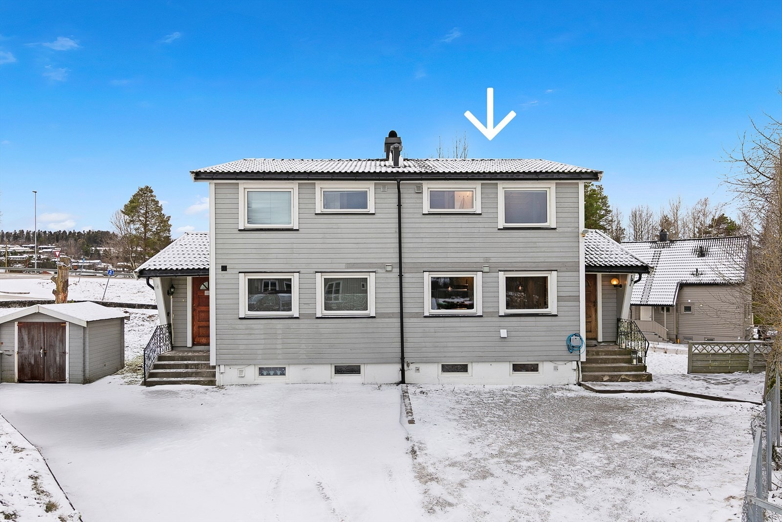 På fremsiden av boligen er det gruset gårdsplass, samt montert lader til elbil. Galleribilde