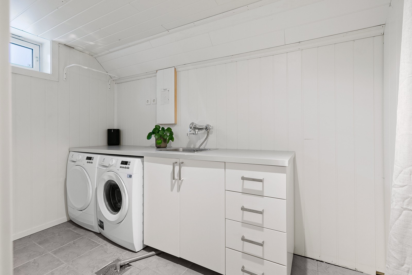 Vaskerommet er innredet med skap med slette fronter og nedsenket utslagskum, og det er opplegg for vaskemaskin og plass til tørketrommel. Galleribilde