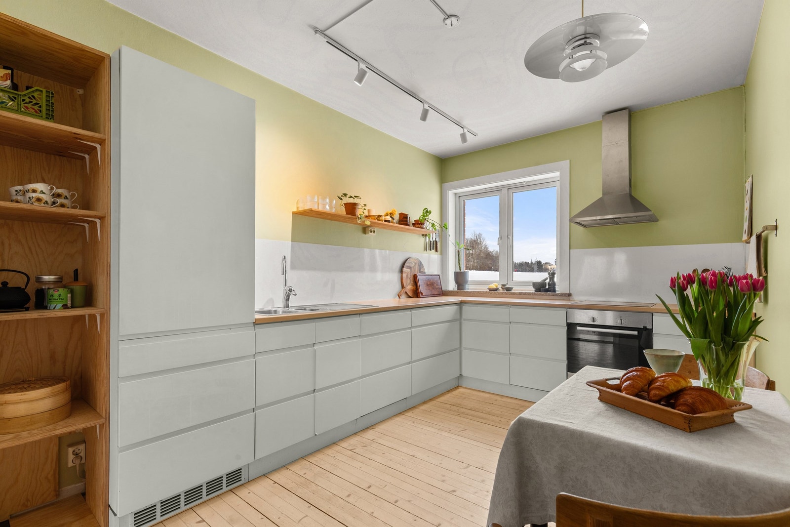 Tidløst og flott kjøkken med glatte fronter og laminat benkeplate med nedfelt vaskekum. Fra både kjøkkenet og ene soverommet har man flott utsyn til sletta bak blokka. Galleribilde