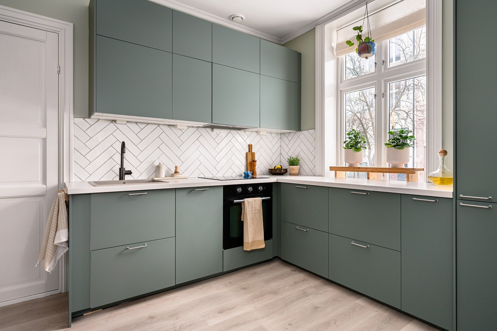 Fargevalget er godt gjennomtenkt, med en grønn fargepalett som går igjen både på kjøkkenfronter og vegger. Galleribilde
